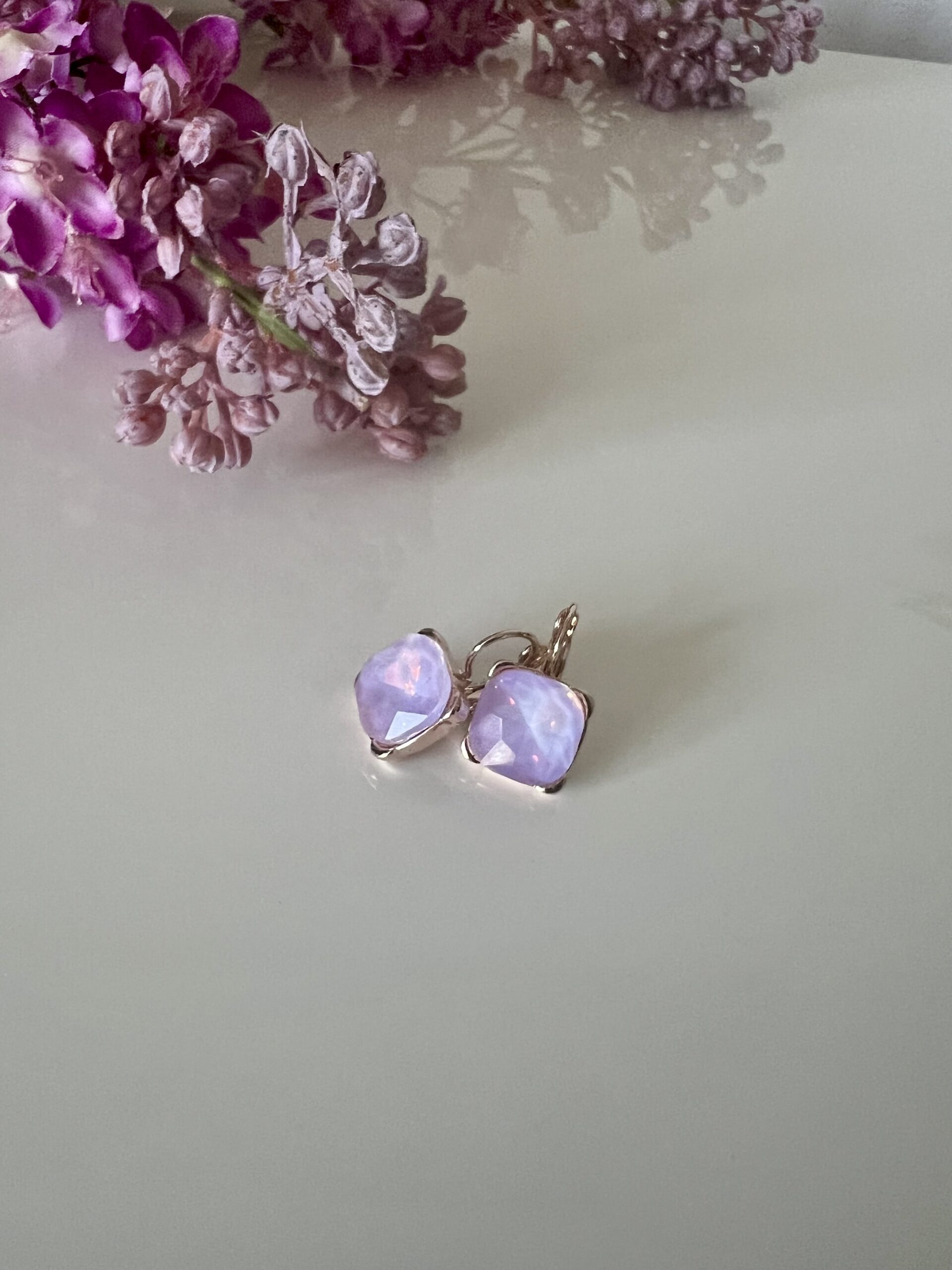 Rosegouden vierkante oorhangers met violet swarovski steen
